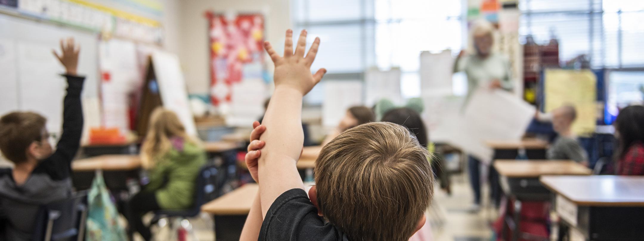 A child has a question in an elementary classroom